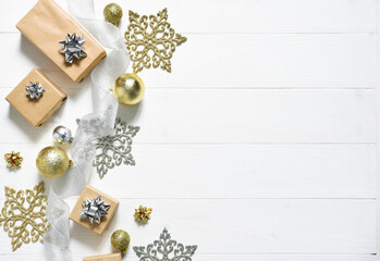 Beautiful Christmas composition on a white background with a gift box, silver ribbon and Christmas balls. View from above.