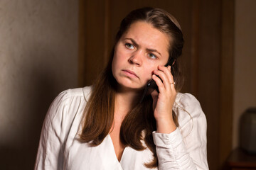 A young dissatisfied woman is talking on the phone
