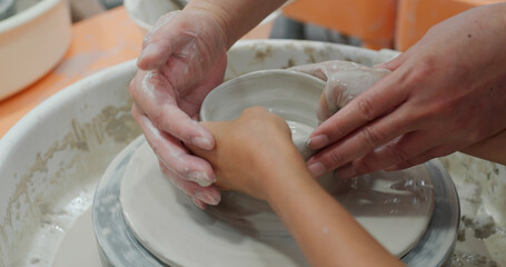 Student work on making ceramic pot on turning pottery wheel