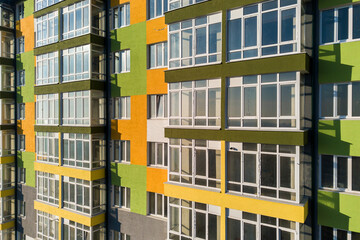 Obraz premium Aerial view of a tall residential apartment building with many windows and balconies.