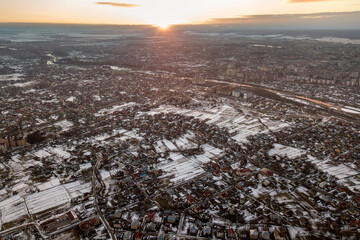 Top view of city suburbs or small town nice houses on winter morning on cloudy sky background. Aerial drone photography concept.