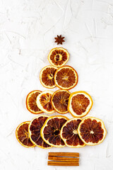 Christmas tree made of dried citruses and cinnamon on white background.