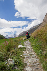Fototapeta na wymiar Hiker on trail near Zermatt, Valais canton, Switzerland (vertical)