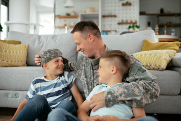 Obraz premium Happy soldier sitting on the floor with his family. Soldier enjoying at home with children..