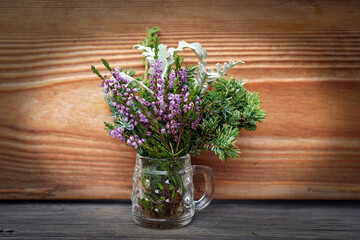 beautiful table decoration, a shot glass with heather and twigs from a juniper