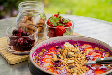 Tasty dragon fruit smoothie bowl with berries and toppings