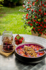 Tasty dragon fruit smoothie bowl with berries and toppings