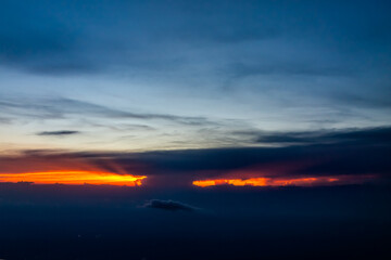 Fototapeta premium Colorful dramatic red dark sunset in Virginia horizon high angle aerial view from airplane window from Dulles airport with skyscape