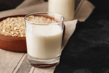 Vegan oat milk with oat flakes close up