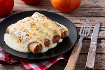 Delicious meat cannelloni pasta on wooden table	