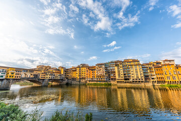 Florence Firenze, Italy orange yellow colorful buildings and Arno river water during summer morning sunrise in Tuscany wide angle view - obrazy, fototapety, plakaty