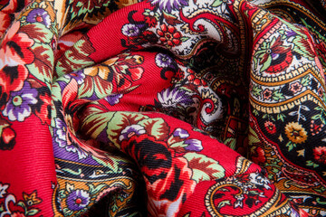 top view closeup on crumpled red cotton scarf with bright floral ornament