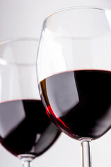 Red wine in glasses on a light gray background close-up.
