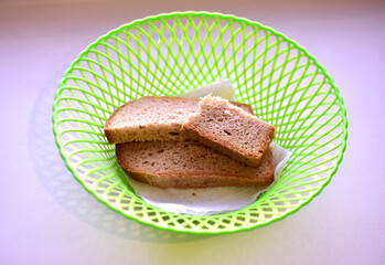 Sliced bread in a plastic bread plate on a white background