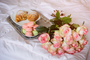 Romantic breakfast in bed and bouquet of roses