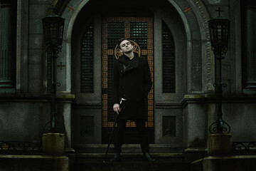 Young elegant vampire in front of a mausoleum - obrazy, fototapety, plakaty