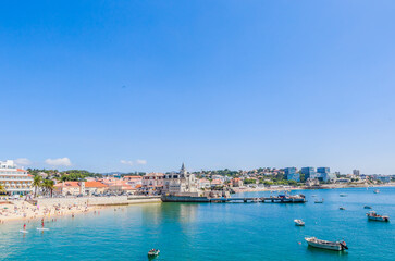 Obraz premium View of the Praia dos Pescadores beach and downtown in Cascais, Portugal, on a sunny day.