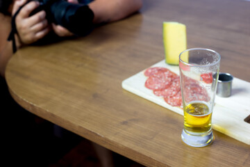 cold cuts board with parmesan cheese, salami with a touch of red pepper and lemon accompanied by beer and cachaça