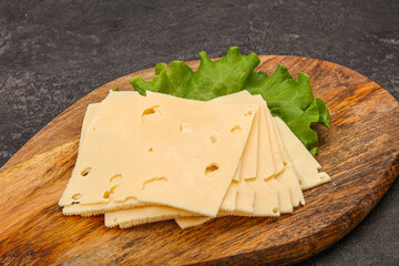 Sliced yellow cheese over board