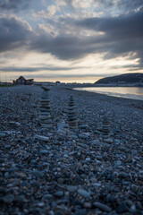 Balancing pebbles on a rocky beach in North Wales. Evening on Llandudno pebble beach