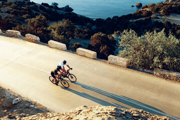Two professional male cyclists riding their racing bicycles in the morning together