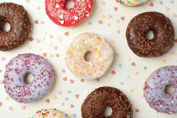 Flat lay with tasty donuts on white background