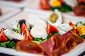 Salad on plate with mozzarella cheese, meat slices tomatoes and eggs in Florence Italy Firenze Centrale Mercato