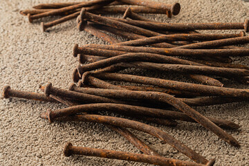 primer plano de clavos oxidados sobre cemento gris