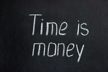 
The inscription on the chalk board Time is money. Common phrase in English