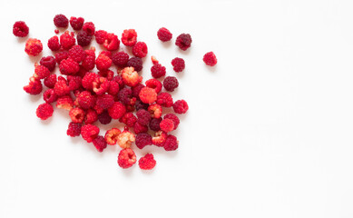 Raspberry background. Raspberries scattered on a white plate with copy space. He insulated one edge. Summer and healthy food concept. Vegetarian concept, healthy food and diet. Top view, copy space.