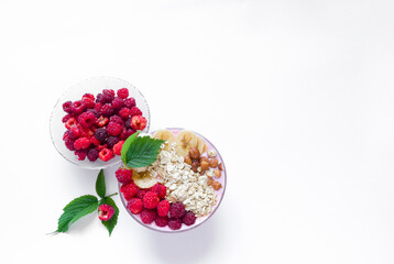 Healthy breakfast bowl: raspberry and fresh raspberry smoothie, banana, yogurt, nuts, oatmeal. Vegetarian concept, healthy food and diet. Top view, copy space.