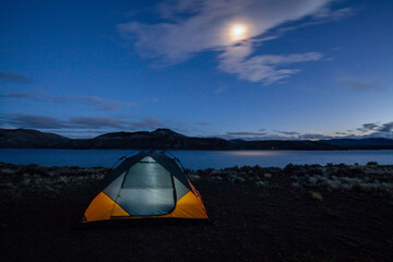 Tent camping near lake at night