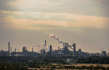 Fototapeta na wymiar Industrial plant in the haze of smog exhaled pipes.