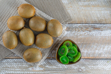 Kiwi with dried slices, kitchen towel flat lay on wooden and placemat background