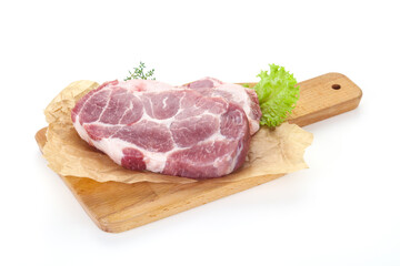 Raw pork steak over wooden board
