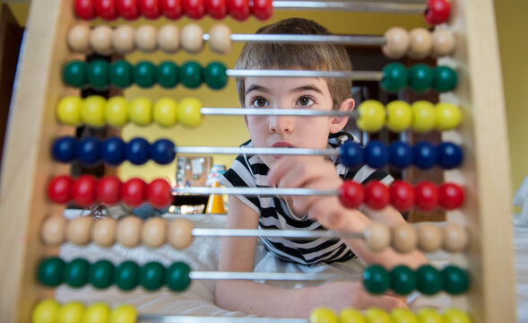 Child plays and learns with an abacus at home