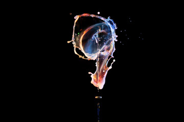 Falling drops of colored liquid, splashes on a black background