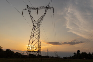 Electricity transmission tower with a sunset in the background.
