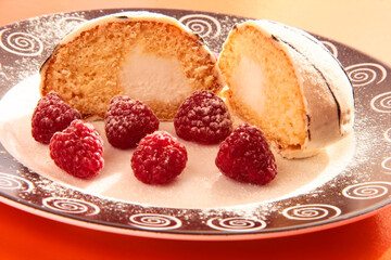 Delicious breakfast. Raspberry berries with sponge cake in powdered sugar on a bright background