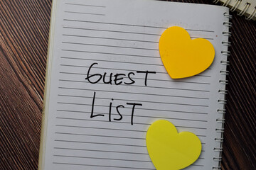 Guest List write on a book with keywords isolated wooden table.
