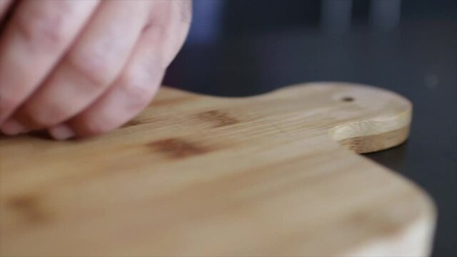 manos picando melon sobre una tabla de cortar