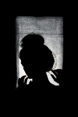 Silhouette of a beautiful woman in a window