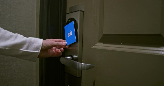 Card key technology at the hotel. Traveler woman is staying at hotel during COVID-19 and opening the door to her room in the resort. The green and red lights are indicating opening door lock, 4K USA