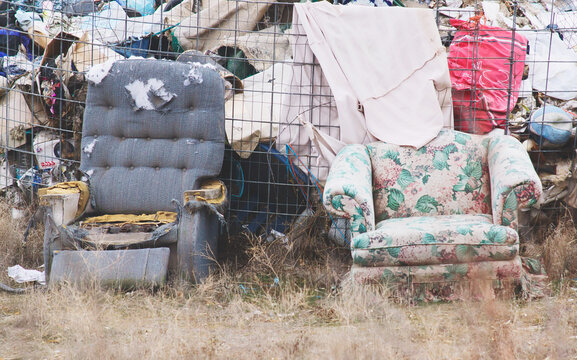 A pair of old torn discarded chairs