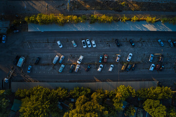 Car parking with cars in the autumn industrial zone at sunset.