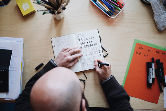 A designer sketching behind his desk at home
