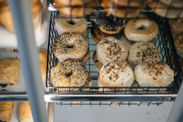 Bagels on display in a bakery pastry case