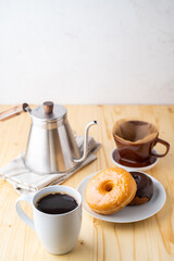 coffee and doughnut on bright pine table
