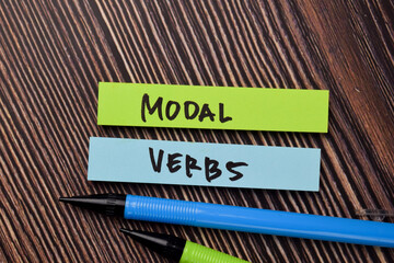 Modal Verbs write on sticky notes isolated on office desk.