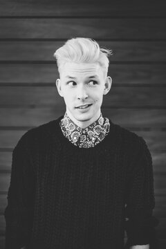 A portrait of a young blonde man looking away